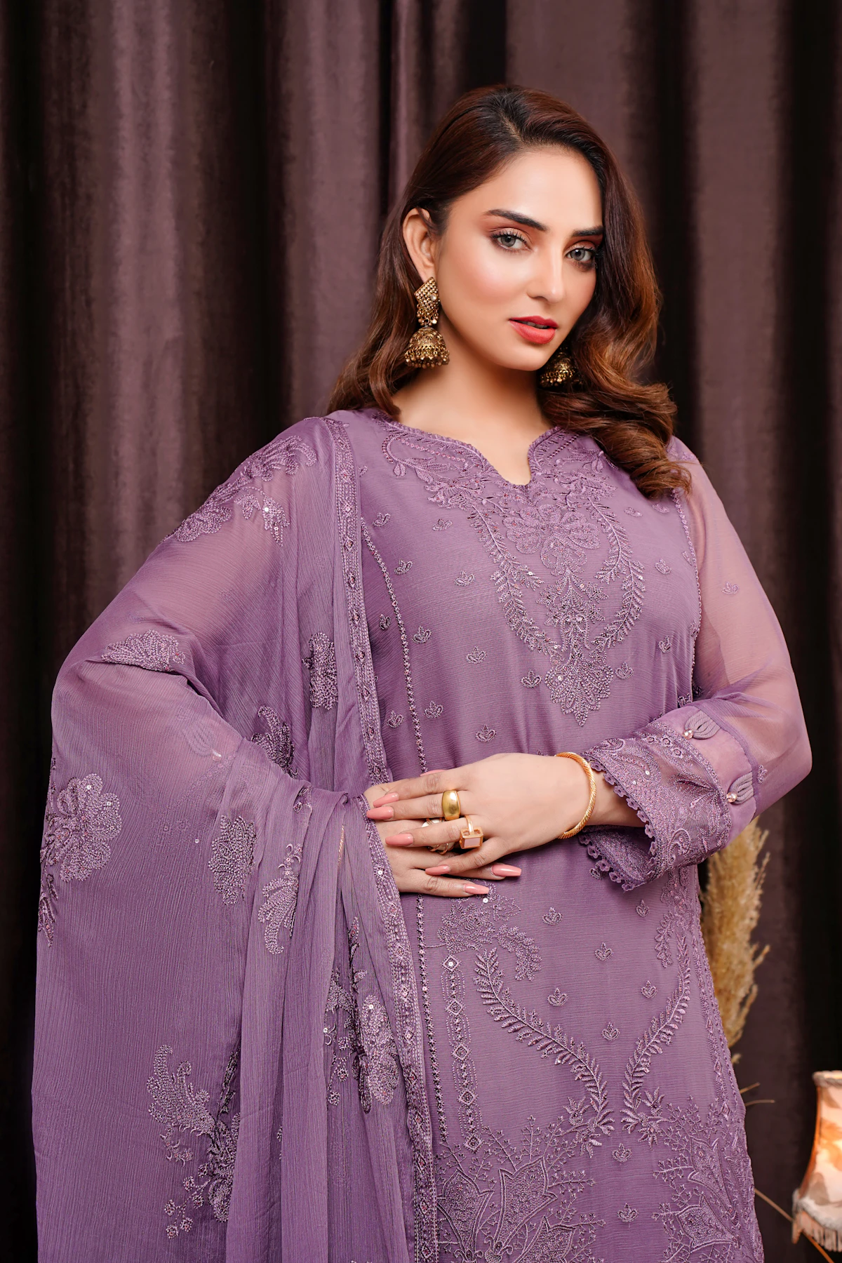 A woman in a lilac chiffon formal with fine silver embroidery and a matching dupatta over her shoulder.