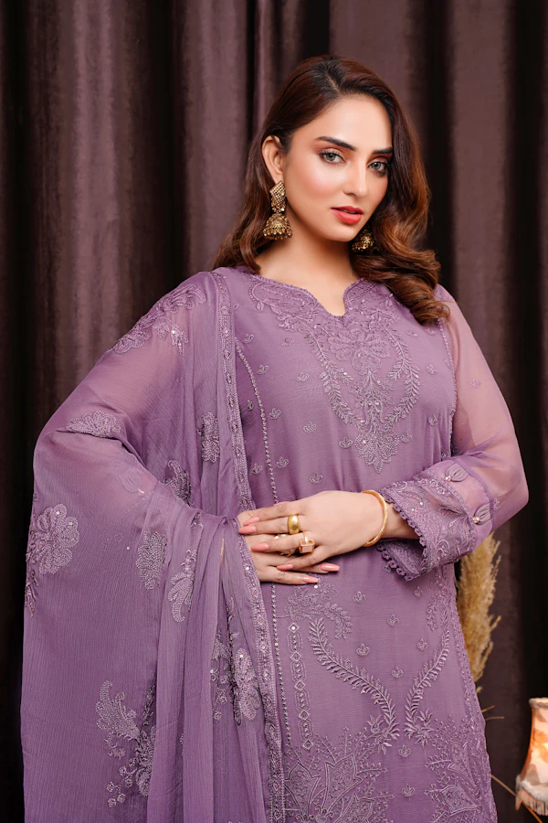 A woman in a lilac chiffon formal with fine silver embroidery and a matching dupatta over her shoulder.